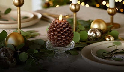 Image of a pinecone flameless candle on a dinner table